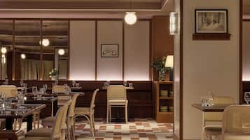 Un restaurant avec un sol à carreaux, des meubles en bois et des luminaires suspendus.