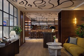 A bar area with a counter, stools, and a bar stocked with bottles. - Miiro Spittelberg NEW OPENING (Vienna)