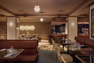 Interior de restaurante com cabines, mesas e área de bar.