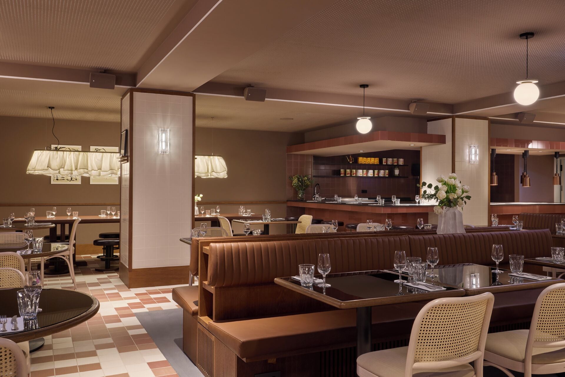 A restaurant with booths, round tables, and a bar area.