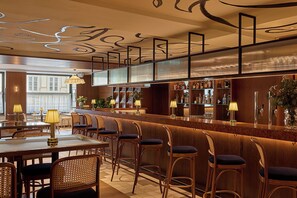 A bar area with wooden chairs, a bar counter, and a view of the street outside. - Miiro Spittelberg NEW OPENING (Vienna)