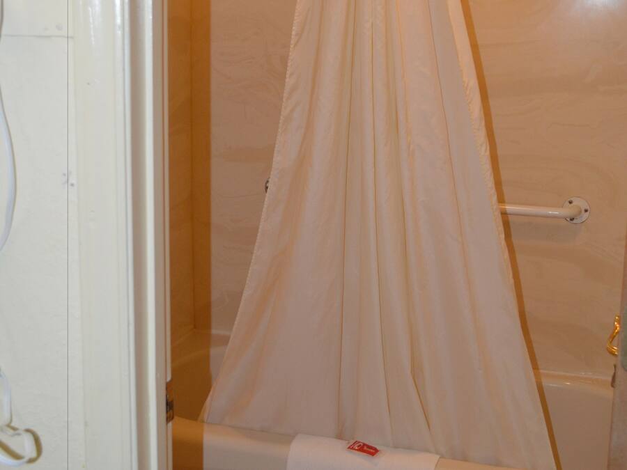 Un bagno con una vasca, il water e una tenda da doccia.