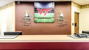 A reception desk with a large VT logo and a football field graphic.