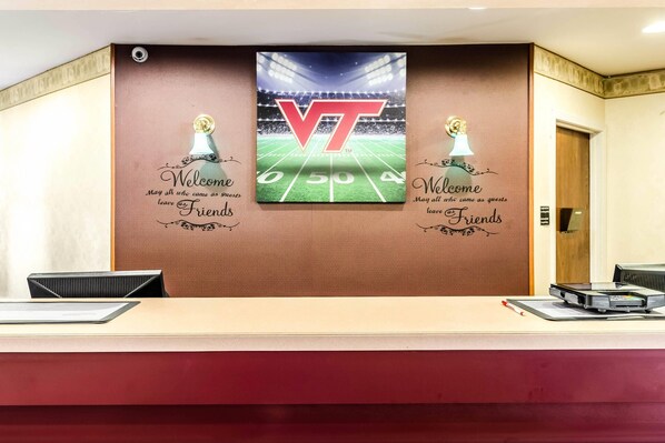 A reception desk with a large VT logo and a football field graphic.