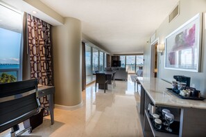 A modern hotel room with a large window, a dining area, and a kitchen. - DoubleTree by Hilton Grand Hotel Biscayne Bay (Miami)