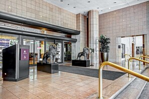 A modern lobby with a tiled floor, a reception desk, and two lion statues. - DoubleTree by Hilton Grand Hotel Biscayne Bay (Miami)