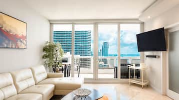 Una sala de estar moderna con un sofá, una mesa de centro y un televisor montado en la pared.