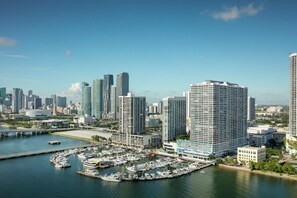 A marina with boats docked, surrounded by high-rise buildings and a clear sky. - DoubleTree by Hilton Grand Hotel Biscayne Bay (Miami)