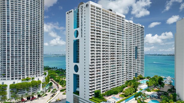 A high-rise hotel with a modern design, featuring a prominent 'DOUBLETREE' sign, multiple balconies, and a view of the ocean. - DoubleTree by Hilton Grand Hotel Biscayne Bay (Miami)