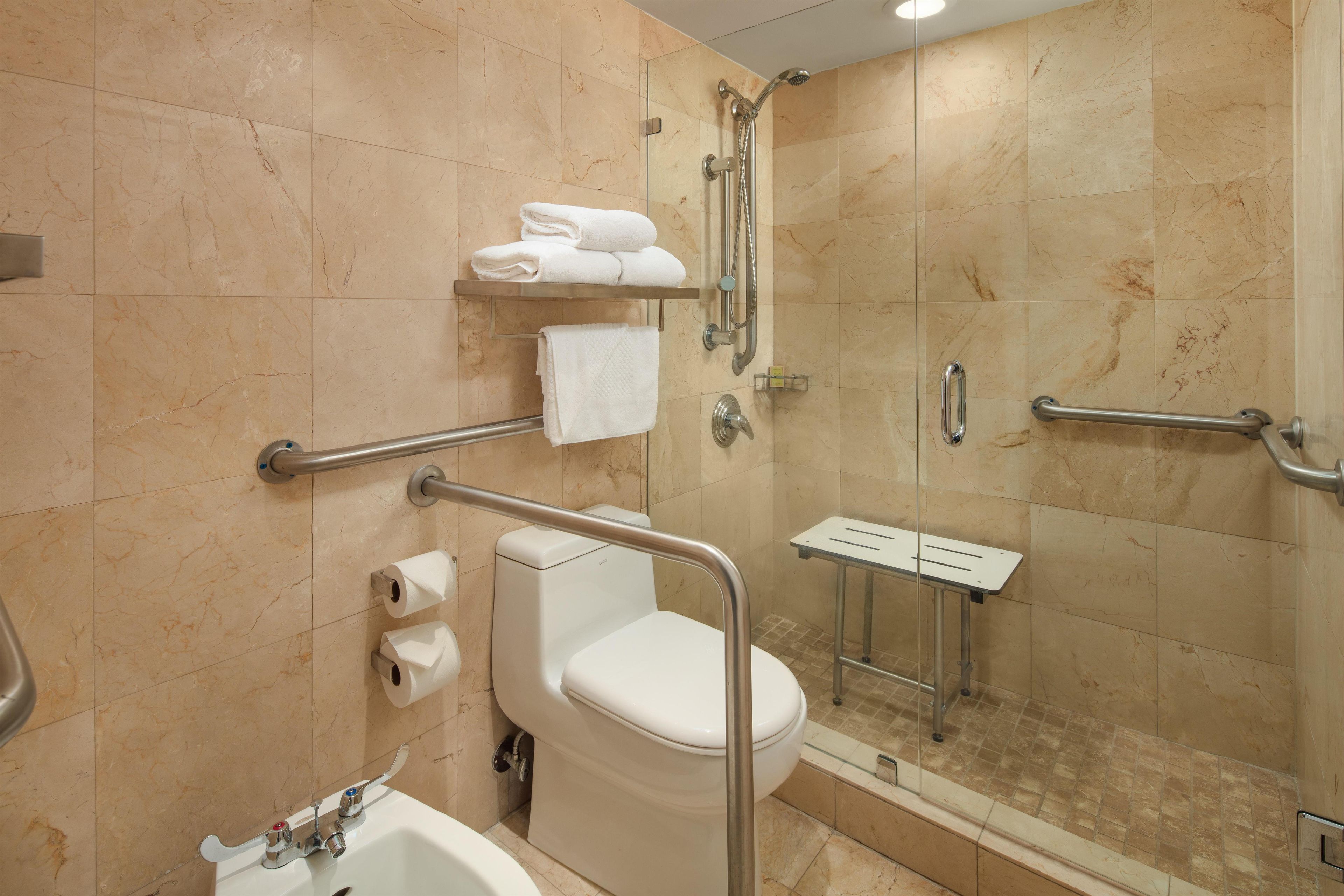 A modern bathroom with a toilet, sink, and shower area.