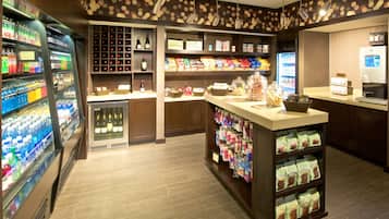 A well-lit convenience store with refrigerated beverages, snacks, and a coffee machine.