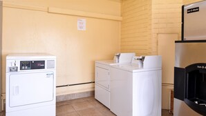A laundry area with a front-loading washer, a stacked dryer, and an ice maker refrigerator. - Americas Best Value Inn Ozona (Ozona)