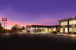 A Red Roof Inn with a spacious parking lot and a building featuring a brick facade and large windows. - Red Roof Inn Winchester - Lexington East (Winchester)