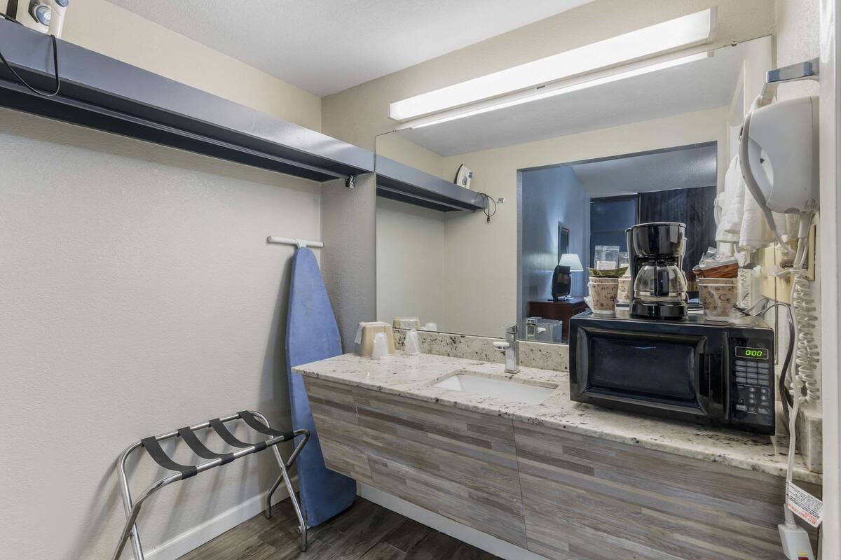 A modern kitchen with a microwave, coffee maker, and a sink.