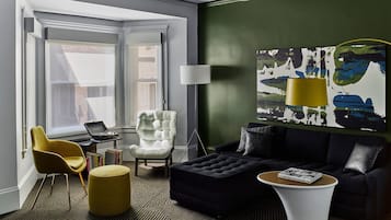 A modern living room with a sofa, armchair, ottoman, and a coffee table.