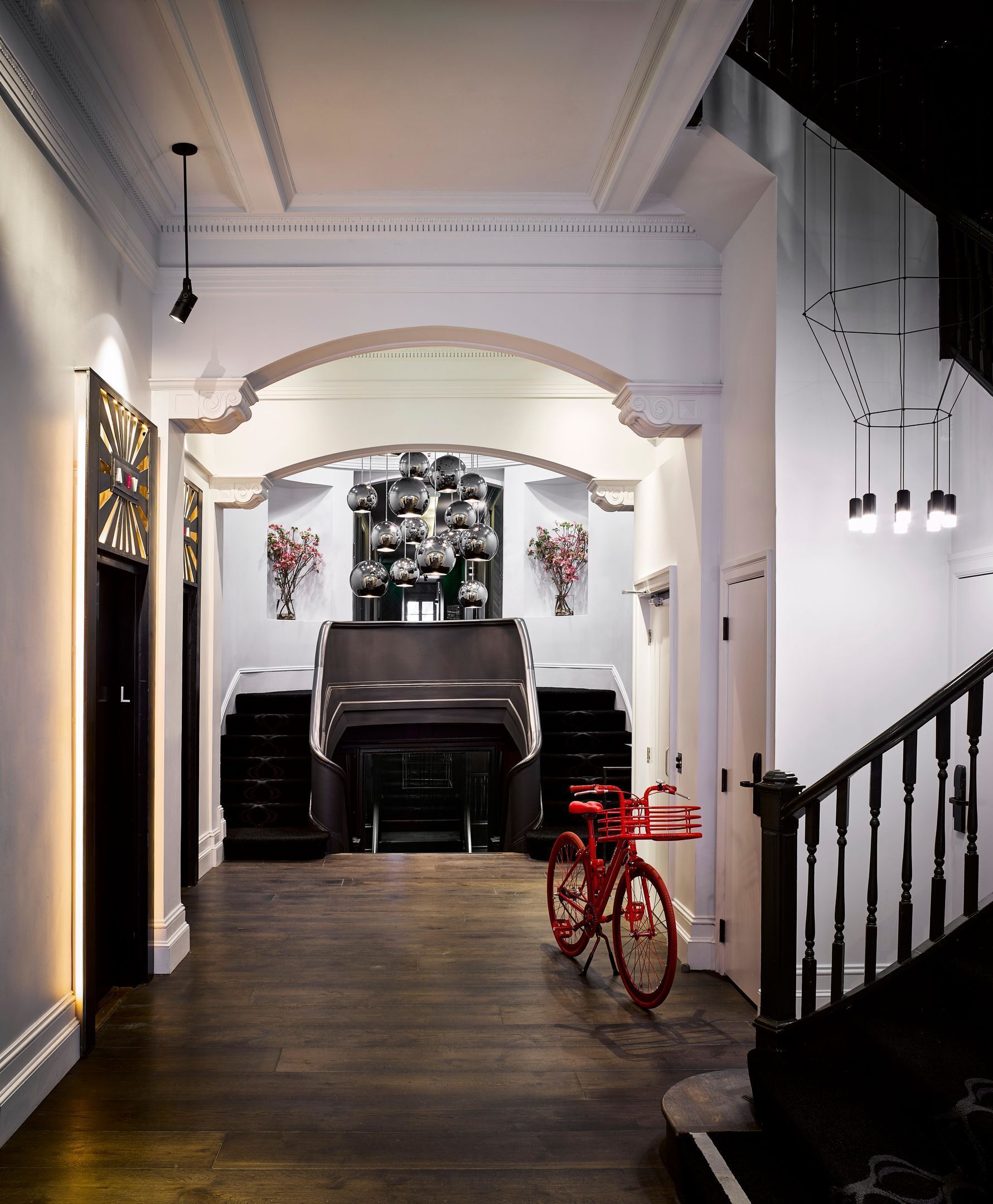 A hallway with a fireplace, a red bicycle, and a staircase.