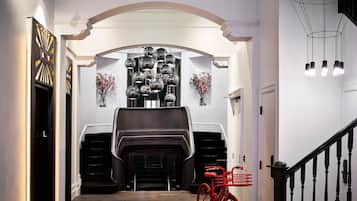 A hallway with a fireplace, a red bicycle, and a staircase.