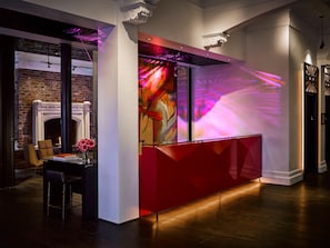A modern lobby with a fireplace, a reception desk, and a large abstract mural. - Hotel Zeppelin San Francisco (San Francisco)