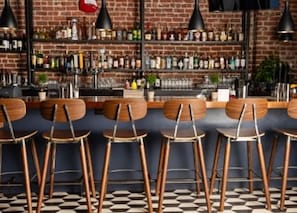 A bar with wooden chairs and a checkered floor. - Hotel Zeppelin San Francisco (San Francisco)