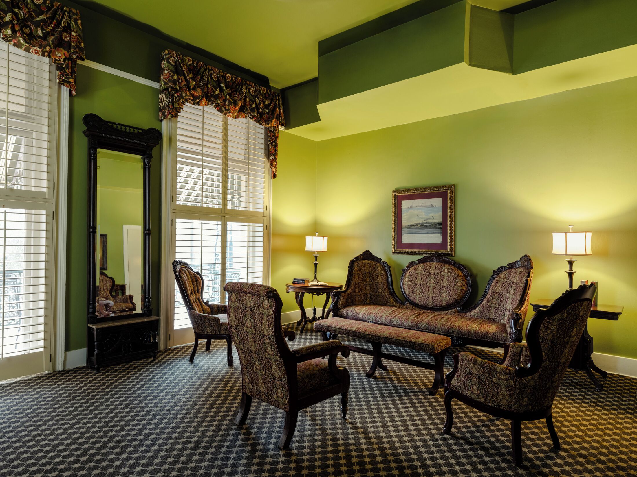 A room with a checkered floor, a sofa, armchairs, and two lamps.