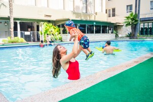 Una piscina al aire libre, sombrillas, sillones reclinables de piscina