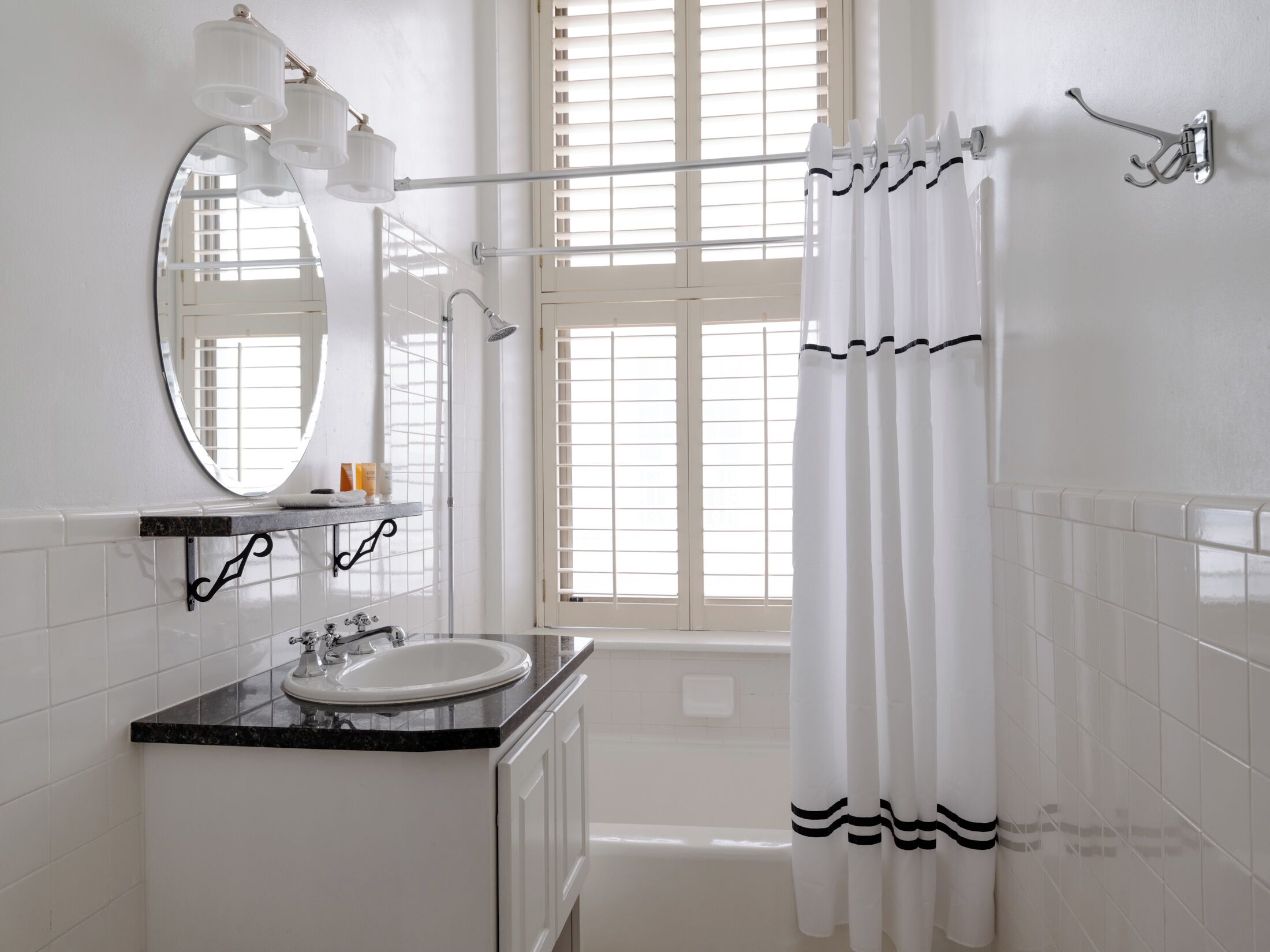 A bathroom with a sink, mirror, and shower curtain.
