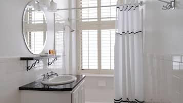 A bathroom with a sink, mirror, and shower curtain.