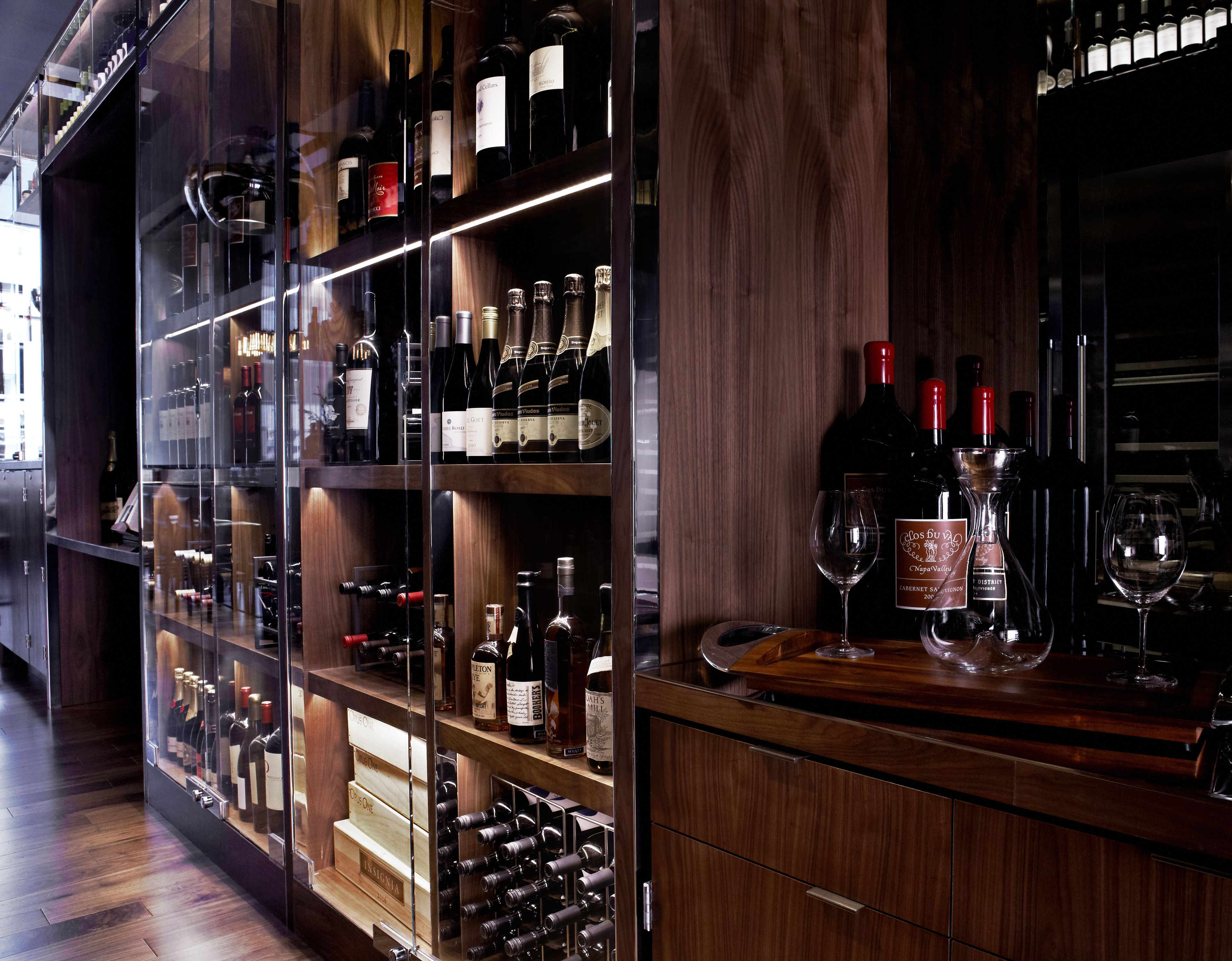 A wine cellar with wooden shelves and racks holding various wine bottles.