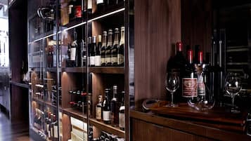 A wine cellar with wooden shelves and racks holding various wine bottles.