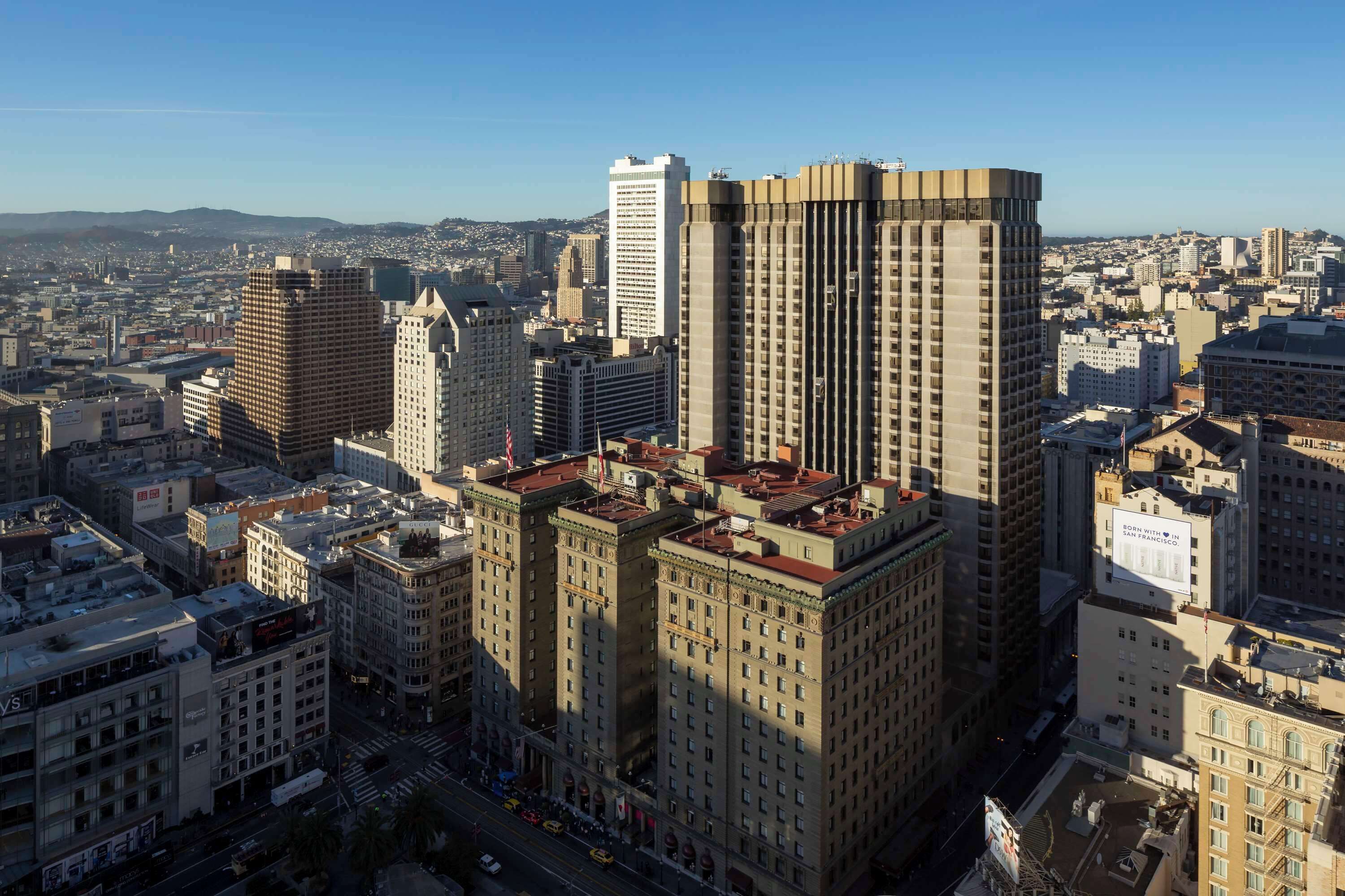 A high-rise building with a prominent corner section, surrounded by other tall buildings in a cityscape.