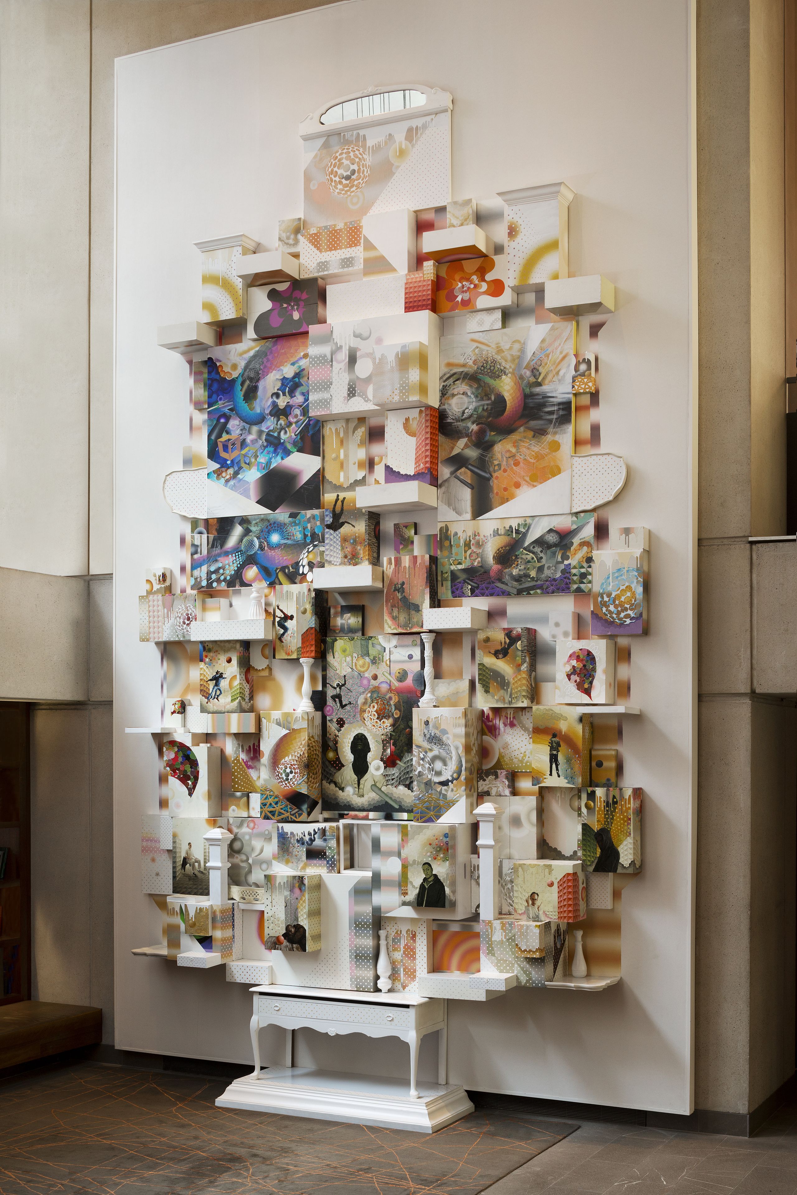 Un mur orné de divers tableaux encadrés et d’objets décoratifs.