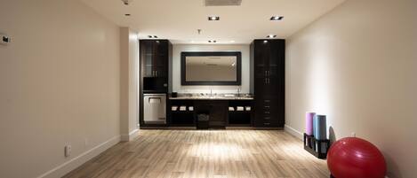 A spacious room with a large mirror, wooden flooring, and a red exercise ball.