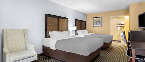 Une chambre d’hôtel avec un grand lit, une chaise, un bureau et un téléviseur.