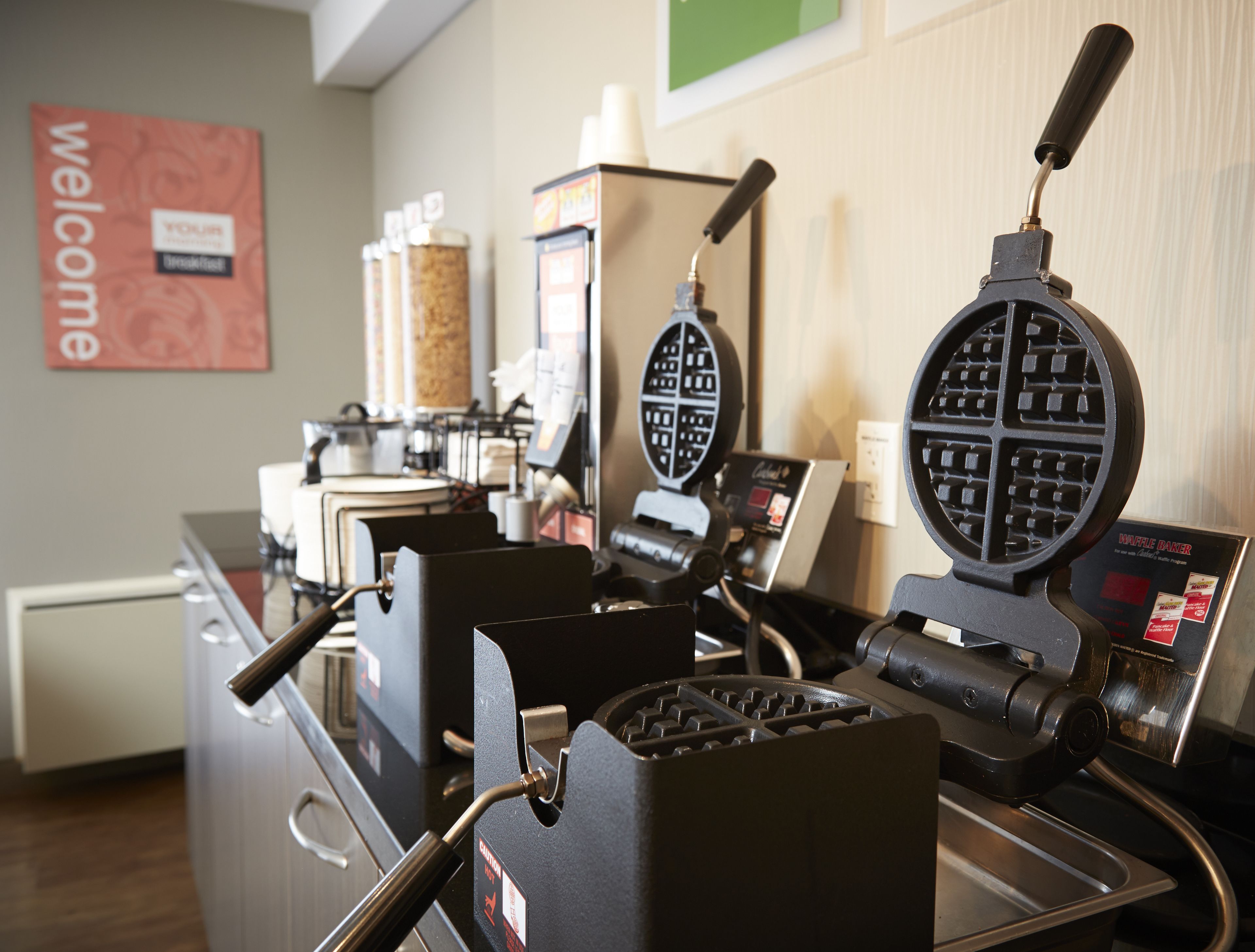A waffle maker and a coffee machine in a kitchen area.