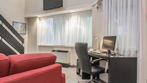 A modern office space with a desk, chair, and a television mounted on the wall. - Comfort Inn Rimouski (Rimouski)