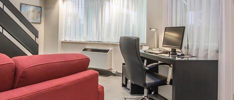 A modern office space with a desk, chair, and a television mounted on the wall.