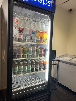 Máquina expendedora con diversas bebidas, como agua embotellada, energizantes y refrescos.