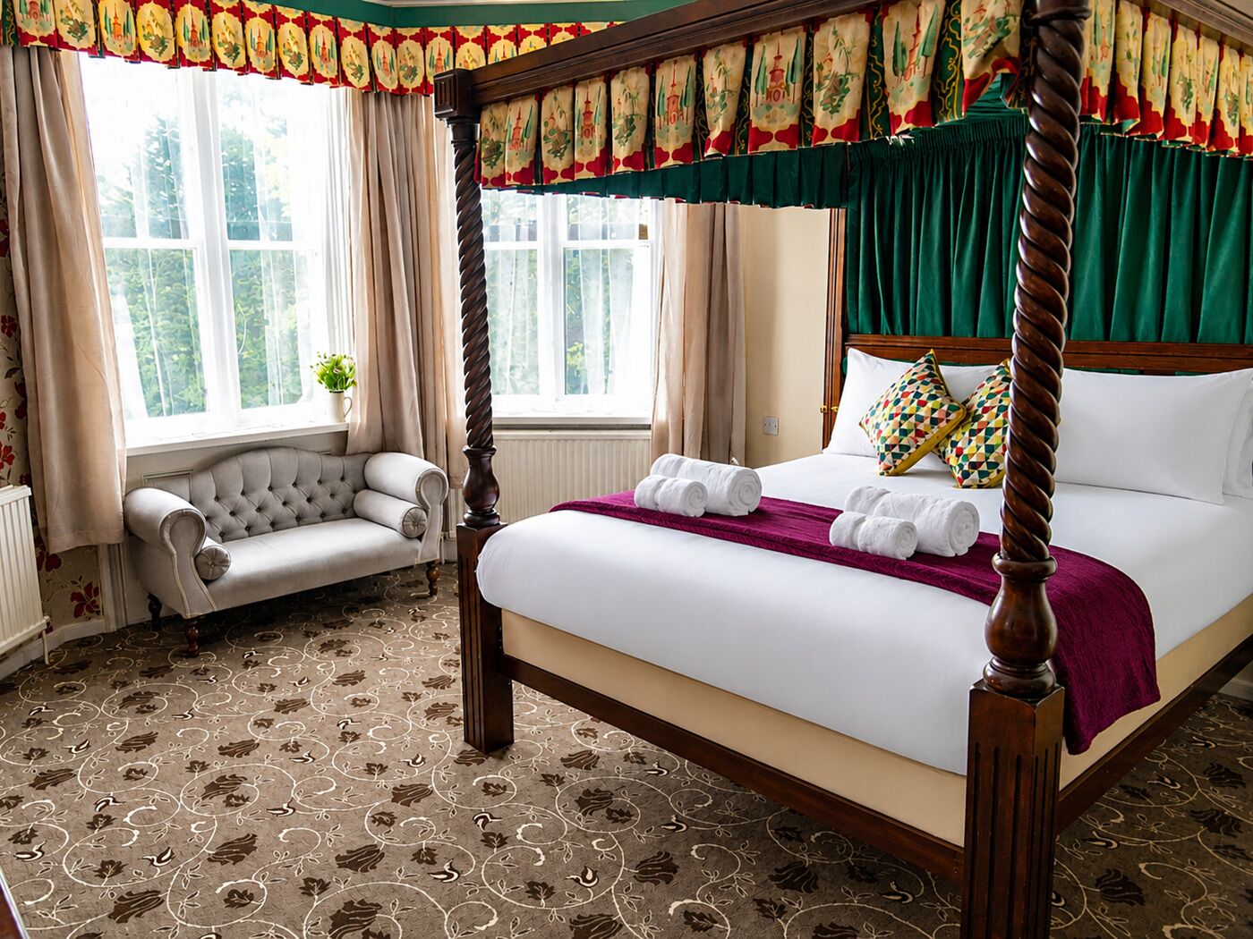 A four-poster bed with rolled towels, a tufted sofa, and a view of greenery through the window.