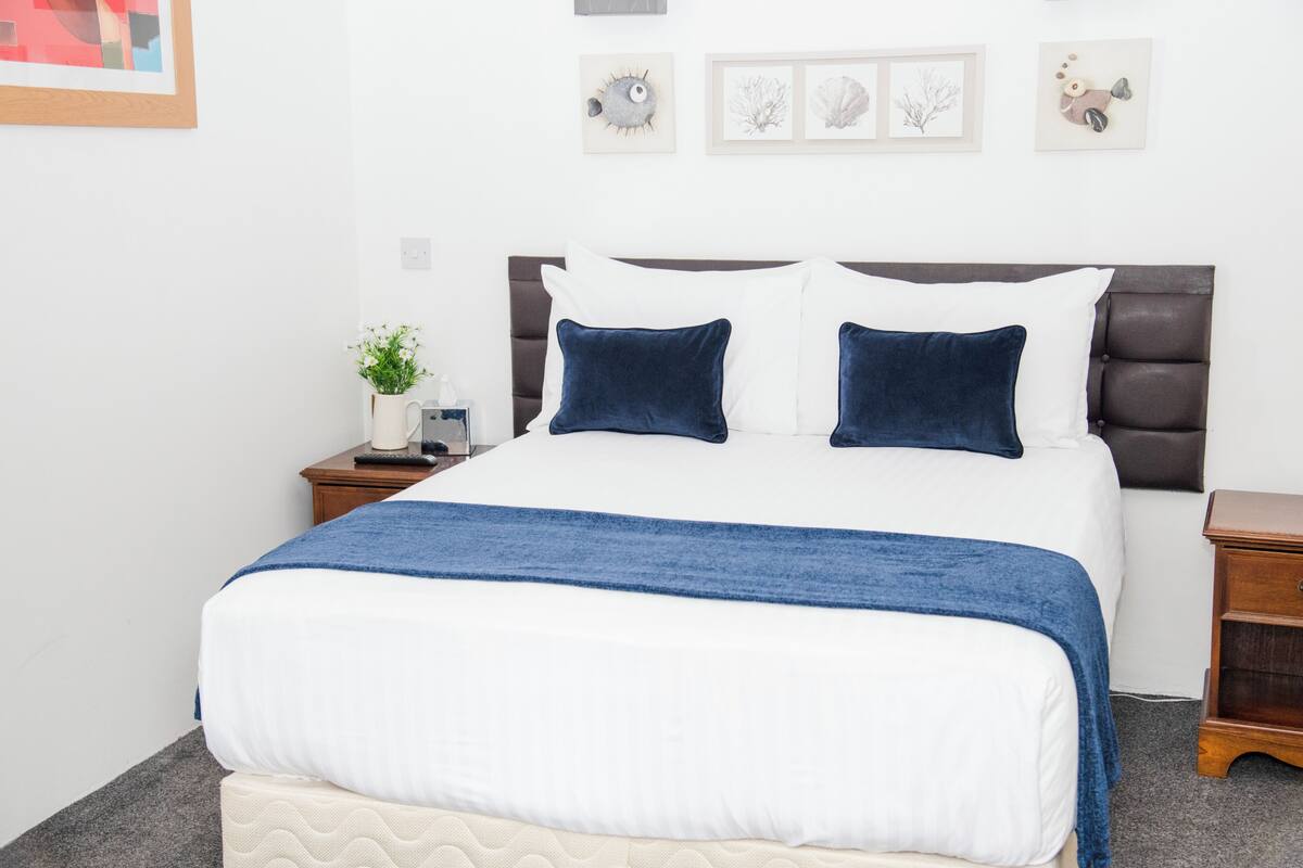 كوخ بتجهيزات أساسية - سرير كبير (Pet friendly room) | أغطية فراش متميزة ومكتب وتجهيزات عازلة للصوت ومكواة/لوح كي