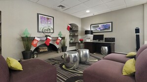 A hotel lobby with a fireplace, Christmas stockings, a television, and comfortable seating.