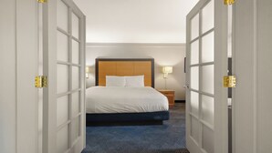 A hotel room with a bed, bedside tables, and a nightstand.