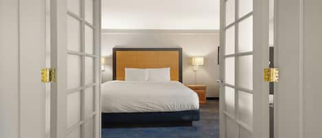 A hotel room with a bed, bedside tables, and a nightstand.
