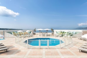 Piscine extérieure, parasols de plage, chaises longues