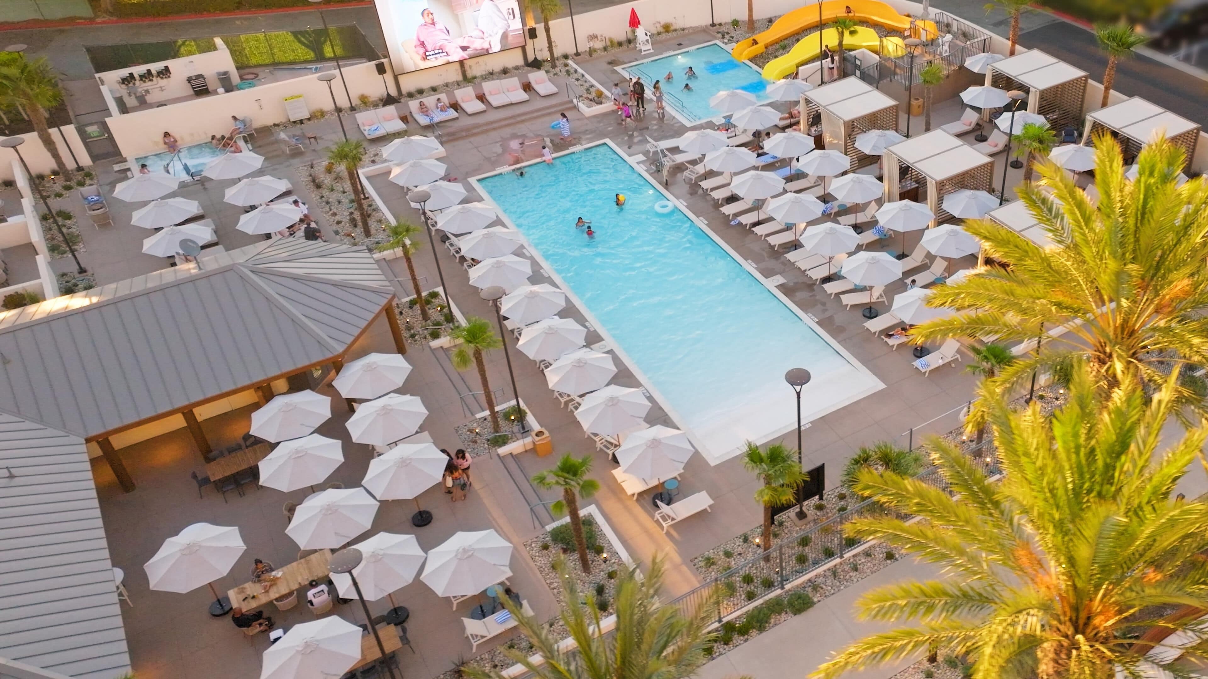 A resort with multiple swimming pools, sun loungers, and umbrellas.