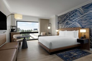 A modern hotel room with a large bed, a desk, a chair, a TV, and a city view. - Hyatt Regency Irvine (Irvine)