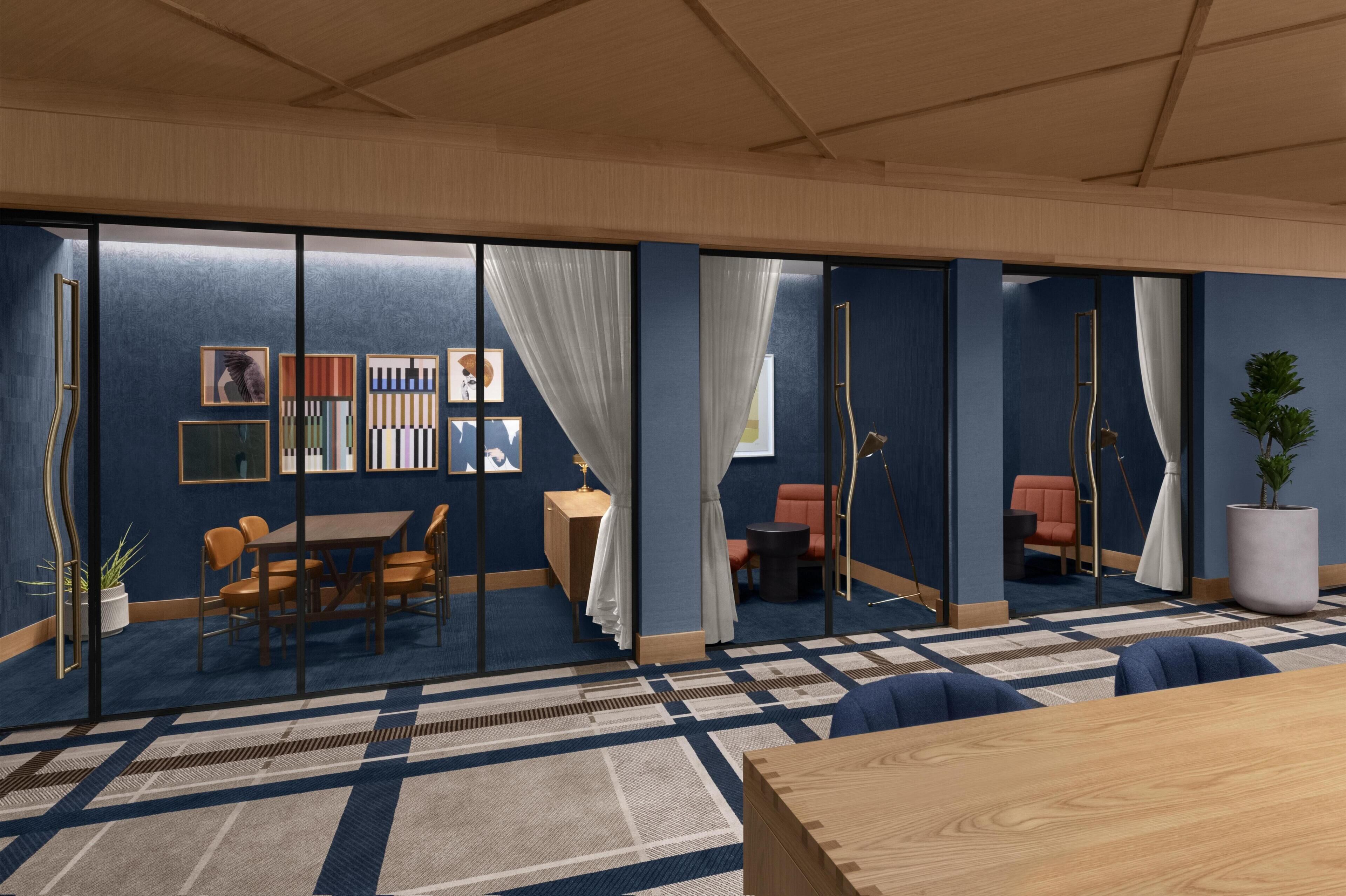 A modern meeting room with glass partitions, a wooden table, chairs, and a patterned carpet.