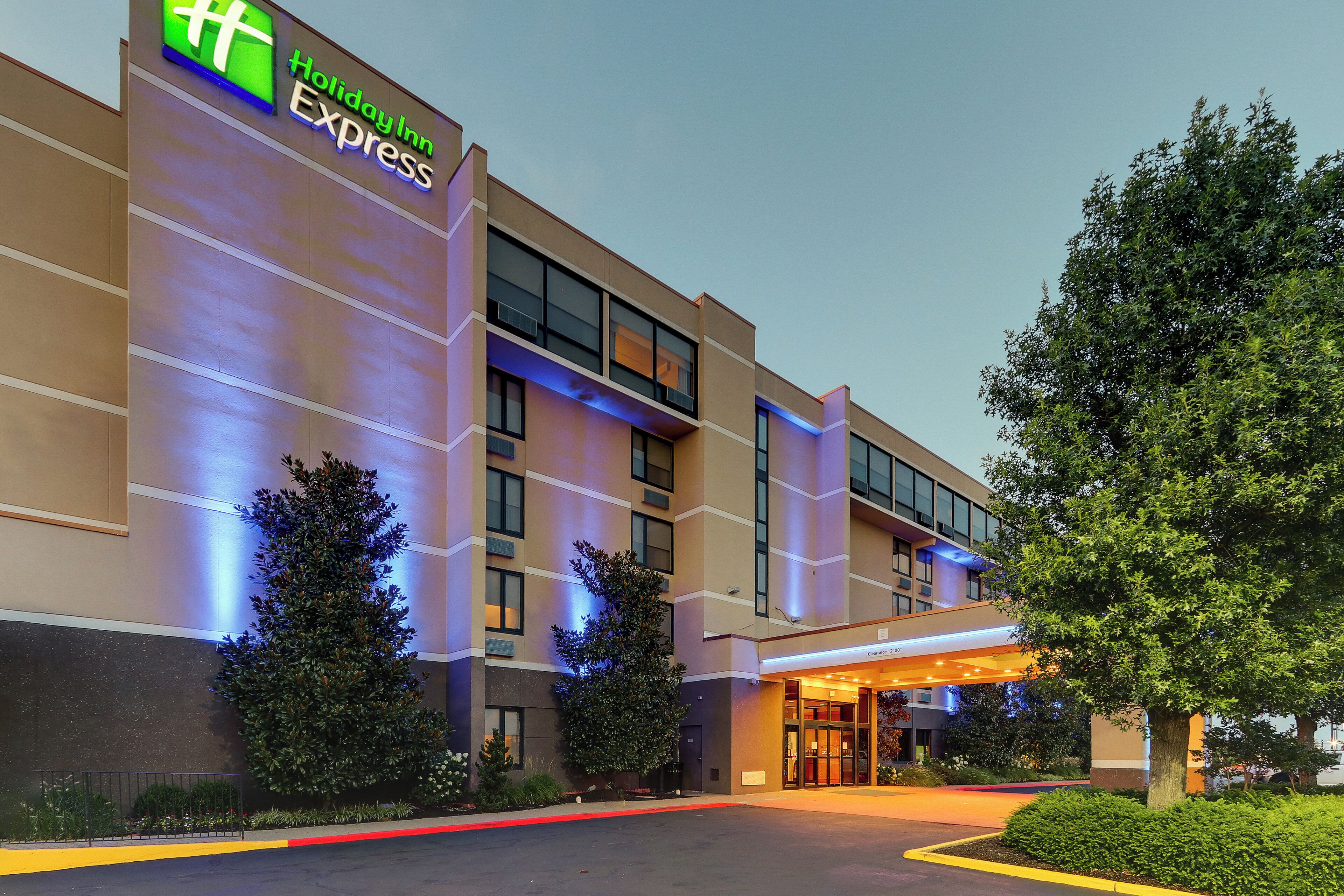 A Holiday Inn Express building with a modern facade, large windows, and a well-lit entrance.