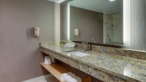 A modern bathroom with a granite countertop, a sink, a large mirror, and a shower area. - Holiday Inn Express Aberdeen by IHG (Aberdeen)
