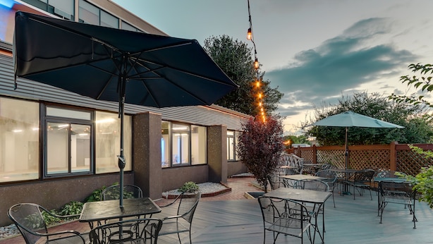 An outdoor patio with tables and chairs, a black umbrella, and string lights. - Holiday Inn Express Aberdeen by IHG (Aberdeen)
