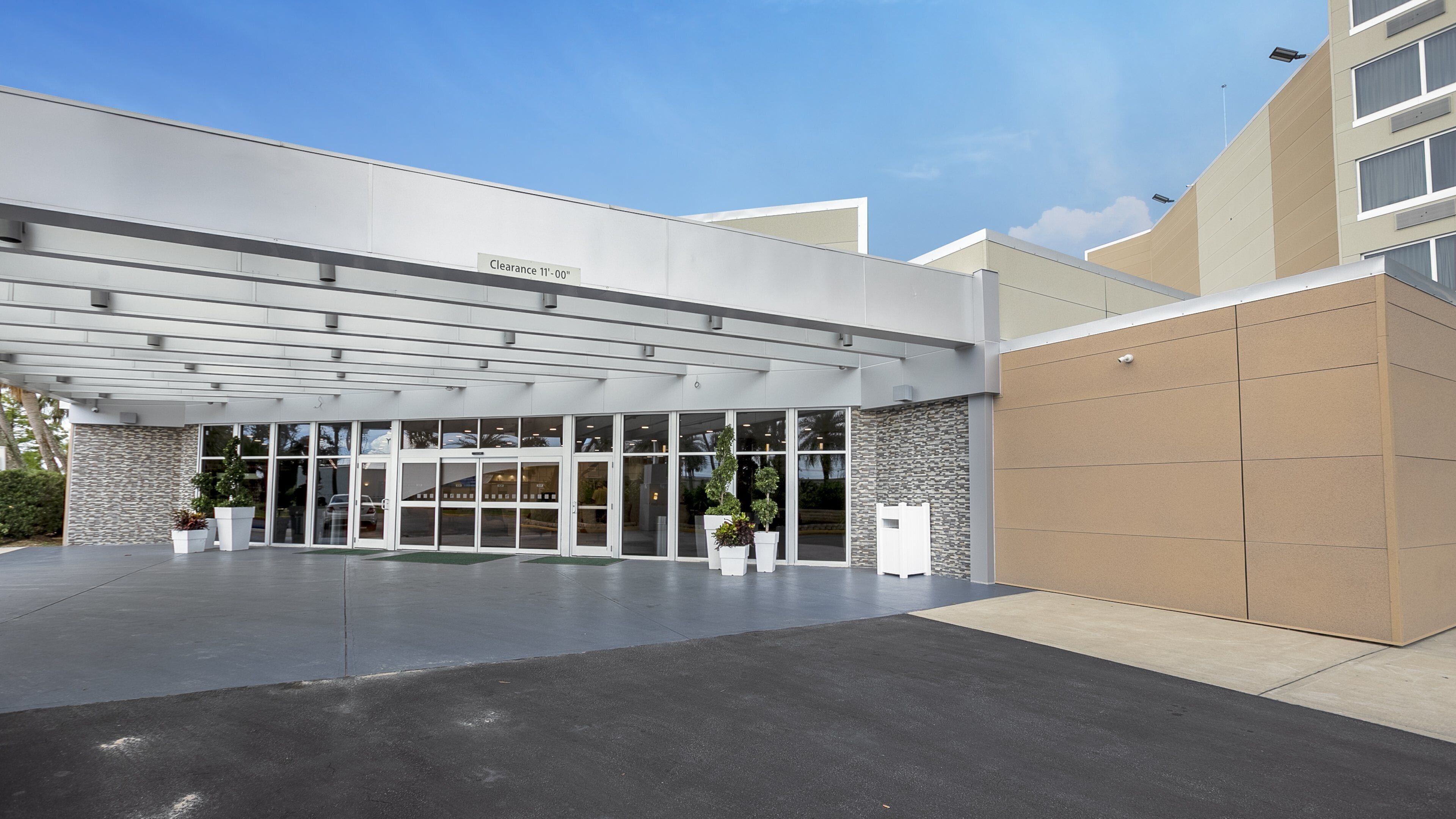 A modern building entrance with a clear sign indicating a clearance of 11'-00'.